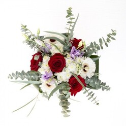Seen through the eyes of a dedicated St John's Wood florist, this bouquet embodies the area's trademark blend of tradition and quiet confidence. The arrangement's focal point-a group of velvety red roses-rises from the center, their spiraled petals a metaphor for enduring affection, much like cherished family gatherings on Abbey Road. Surrounding them, white gerberas stretch their creamy petals toward the light, framed by espresso-brown centers that lend a timeless character and a whisper of nostalgia. Elegant eucalyptus, with silvery-green leaves, arcs above the blooms, catching and reflecting the shifting daylight like the leafy cover along Wellington Road. Sprinkled throughout, soft lilac lisianthus provide a modern, playful accent, echoing the gentle energy felt during spring picnics in Primrose Hill. Clusters of pale white filler flowers and sculptural greenery wrap around the florals, adding layers of texture and filling the arrangement with subtle movement and vitality. Housed in a transparent glass vase, the stems are arranged with the practical attention and grace for which St John's Wood Flowers is known, promising lasting freshness for homes and celebrations alike. Whether the bouquet is destined for a joyful birthday, heartfelt sympathy, or simply to brighten the week, it expresses the expertise, creativity, and trustworthy care of a true local florist.
